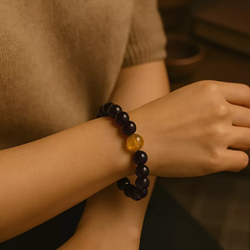 A beaded bracelet made of amethyst and golden rutilated quartz, arranged in a circle on a soft neutral background. The purple and gold tones reflect spiritual wisdom and abundance, ideal for Bazi energy alignment and personal empowerment.