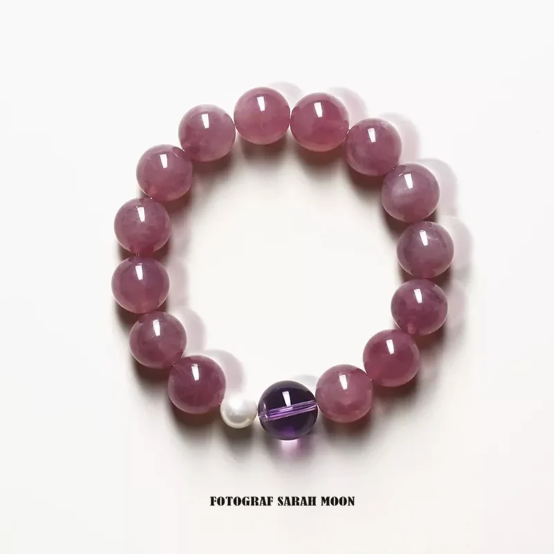 A pink strawberry quartz bracelet made with 10mm round beads, designed to attract love and amplify charisma. The bracelet is infused with Taoist energy and features a soft glow that symbolizes emotional balance and romantic energy.
