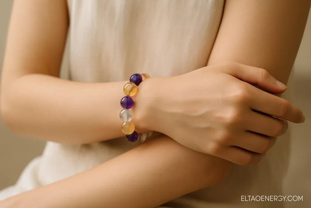 Close-up of crystal bracelets arranged by Five Element colors, laid on neutral fabric.