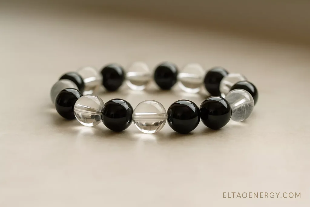 A close-up of a custom energy bracelet made with quartz and obsidian.
